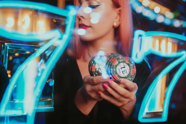 A young woman relaxing with her phone while dynamic casino elements float around her, illustrating the smooth mobile experience offered by the 6777DET app.